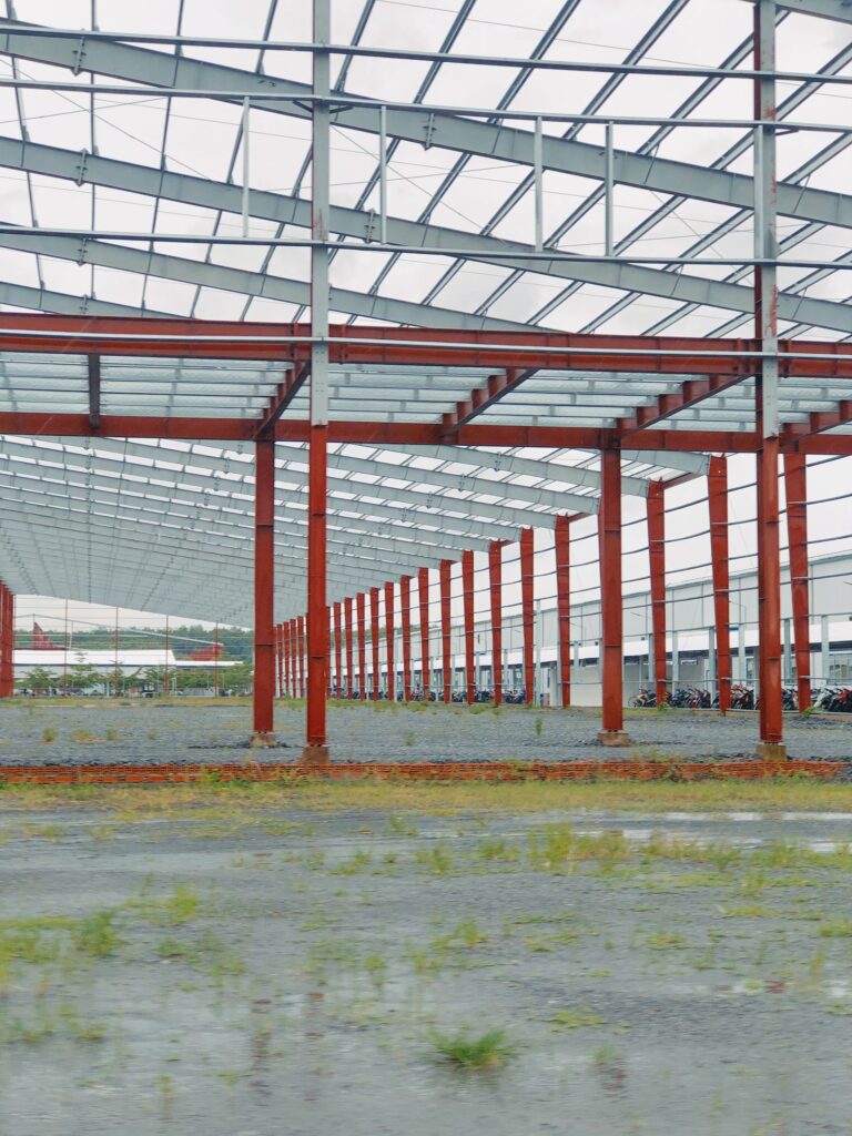 Interior of a large steel-frame industrial structure, showing the scale of structural steel construction